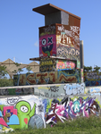 901820 Afbeelding van een ontluchtingskoker, vol met graffiti, op de tijdelijke graffitivrijplaats ('De Kuil van ...